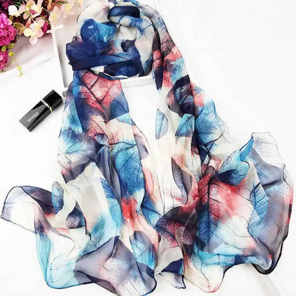A flowing lightweight georgette scarf with a delicate oil painting floral leaf pattern in blue red and white for sunscreen A