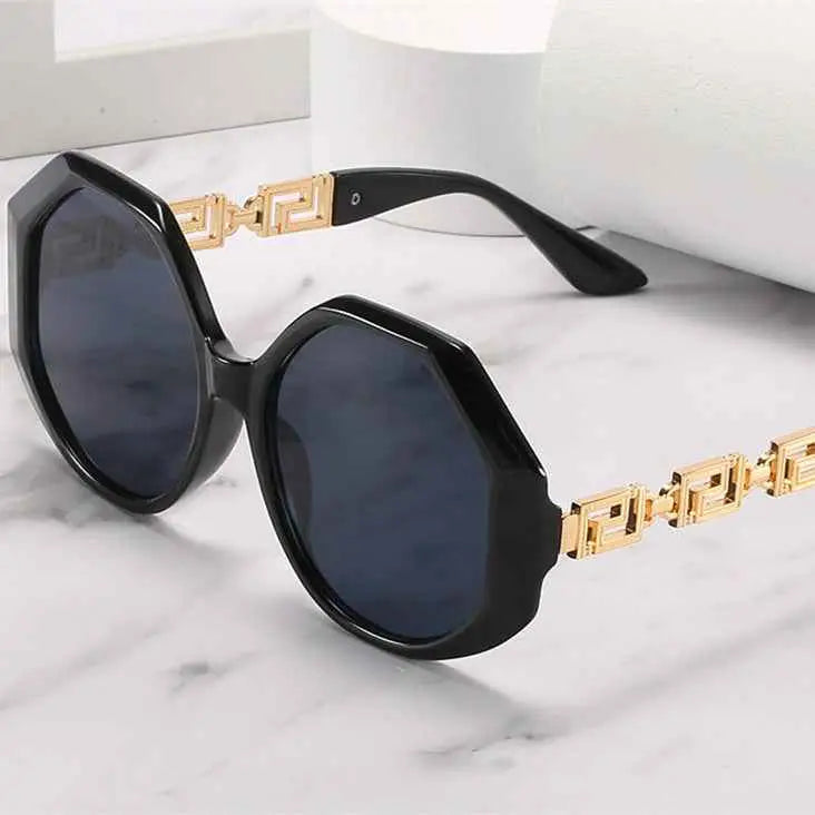 Oversized polygonal designer sunglasses with black octagonal frames gold-tone greek key temples and dark gray lenses