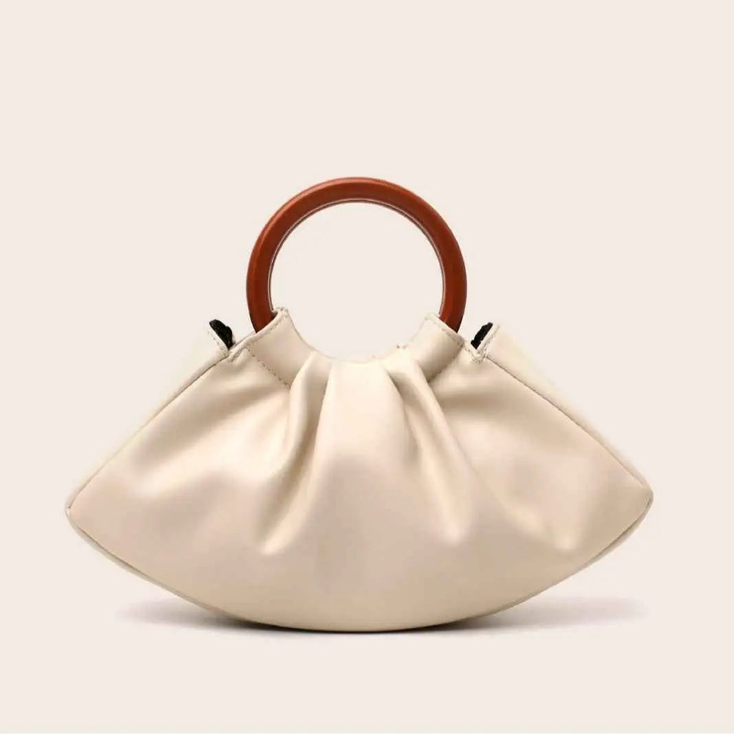 Cream-colored faux leather pleated shell-shaped handbag with smooth finish and circular wooden handle from trend den