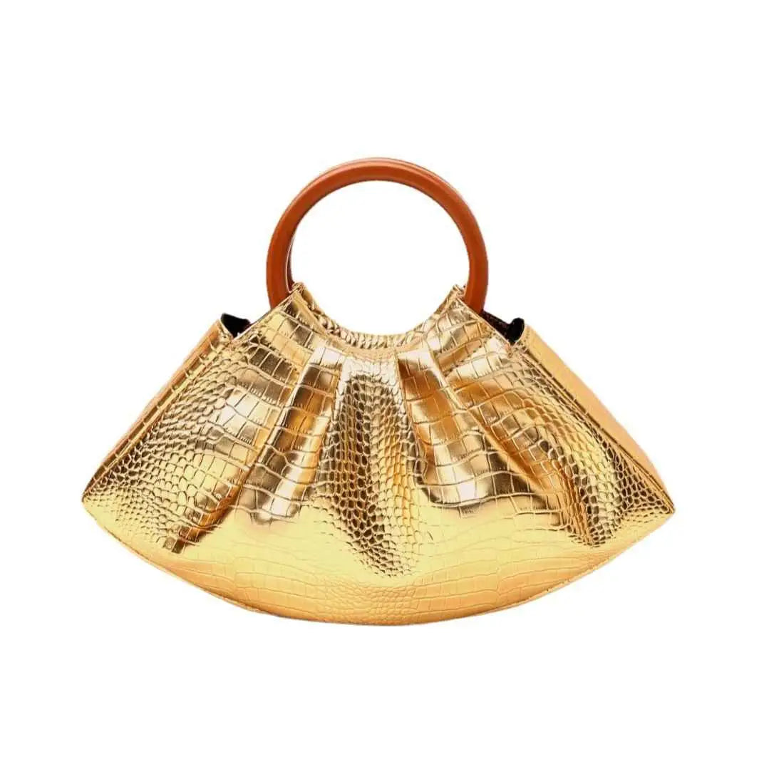 Shimmering gold crocodile-patterned pleated shell-shaped handbag with smooth rounded wooden handle from trend den