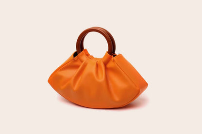 A vibrant orange pleated shell-shaped handbag with smooth body and dark brown wooden handles from Trend Den Orange