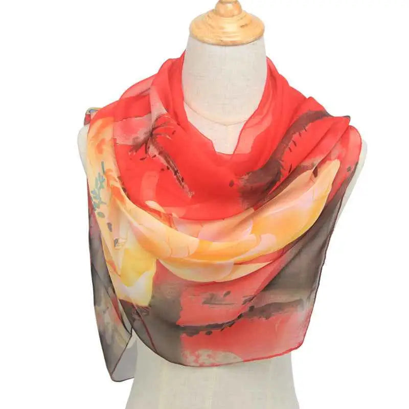 A vibrant red and orange retro ethnic floral georgette sunscreen scarf draped elegantly over a mannequin Red