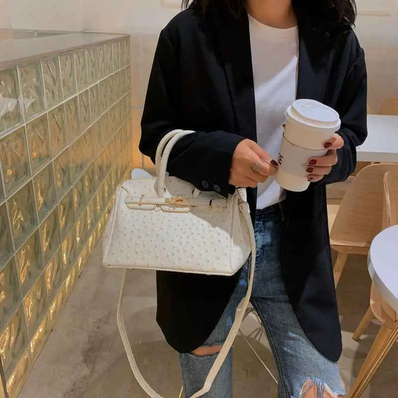 White ostrich-pattern handbag with gold-tone hardware made of durable polyester from trend den luxury collection White