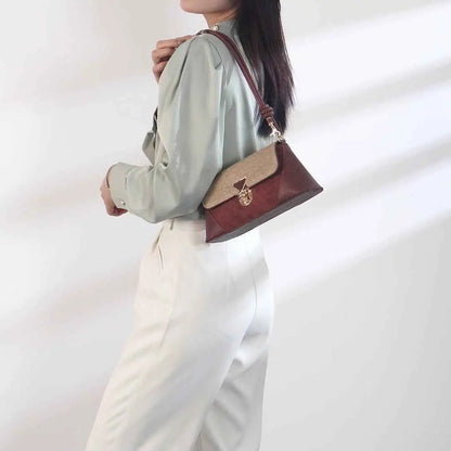 Two-tone leather baguette underarm bag with burgundy body beige flap and gold-toned triangular clasp by trend den