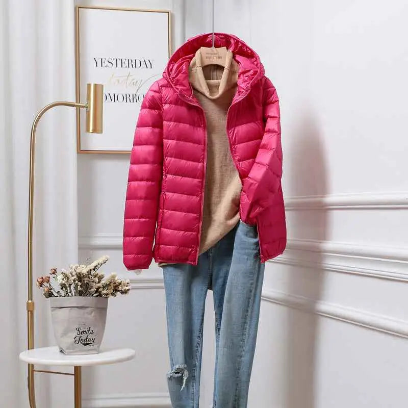 Bright pink quilted ultra-lightweight women’s hooded down jacket with white duck insulation styled with beige turtleneck and jeans from trend den Rose Red