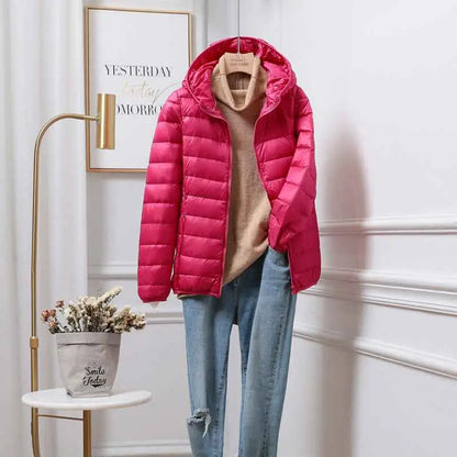 Bright pink quilted ultra-lightweight women’s hooded down jacket with white duck insulation styled with beige turtleneck and jeans from trend den Rose Red