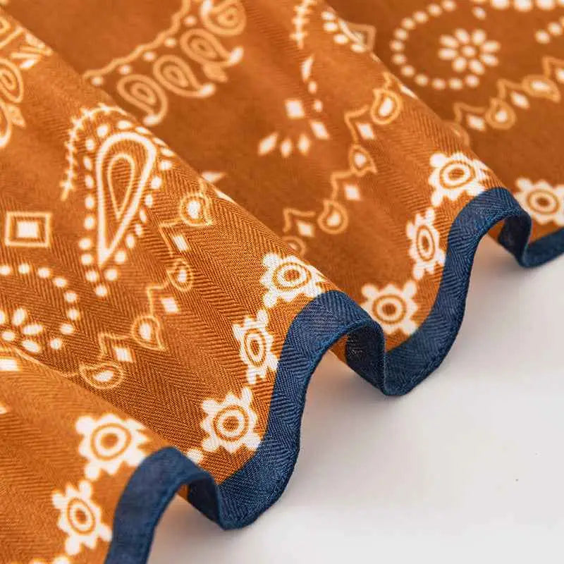 Rust-colored vintage print emulation silk square scarf with white paisley floral pattern and navy blue edging