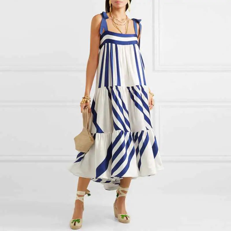 A woman wearing a vintage sleeveless printed midi dress with bold blue and white diagonal stripes