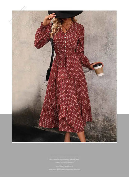 A woman wears a long sleeve printed autumn dress in red with white polka dots and a tiered midi hem