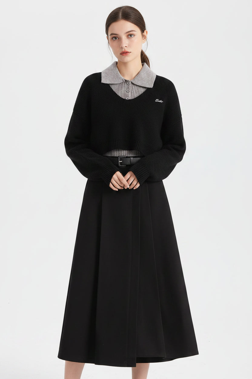 Black cropped winter sweater vest with gray ribbed collar and hem featuring subtle embroidered logo on chest