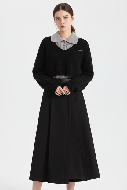 Black cropped winter sweater vest with gray ribbed collar and hem featuring subtle embroidered logo on chest